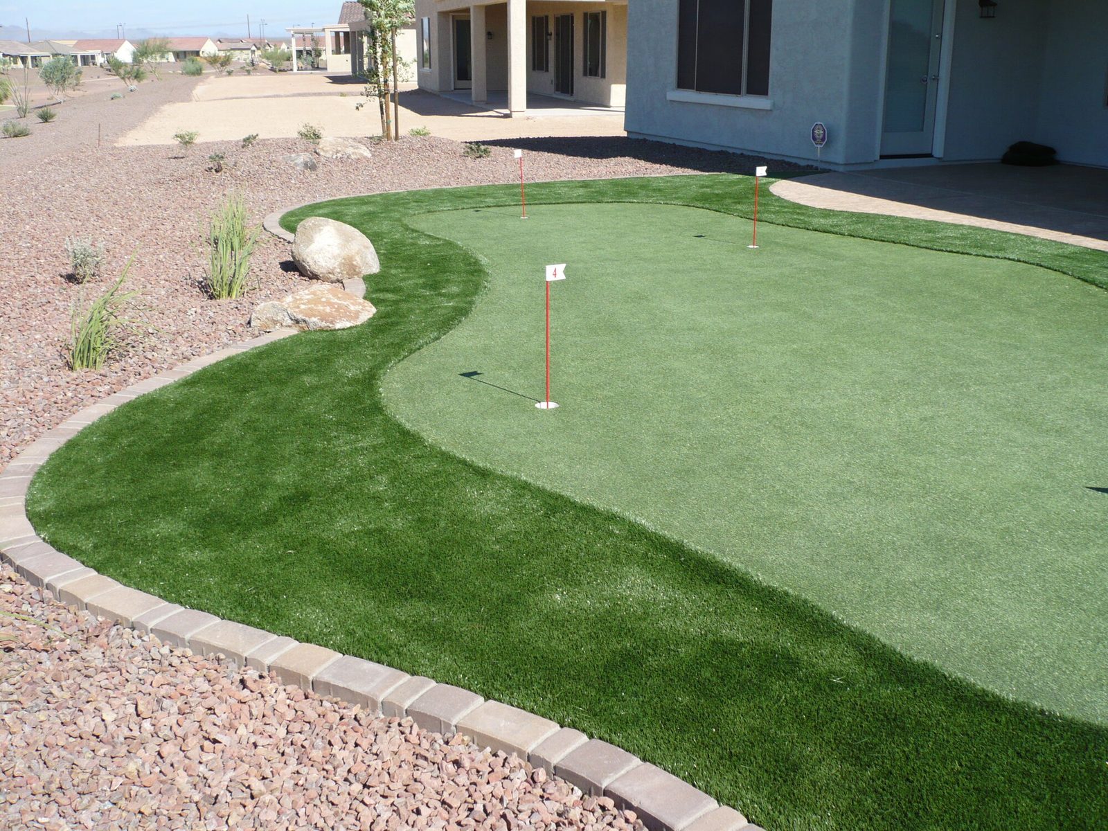 Backyard putting green with desert landscaping, installed by Arizona Turf Masters