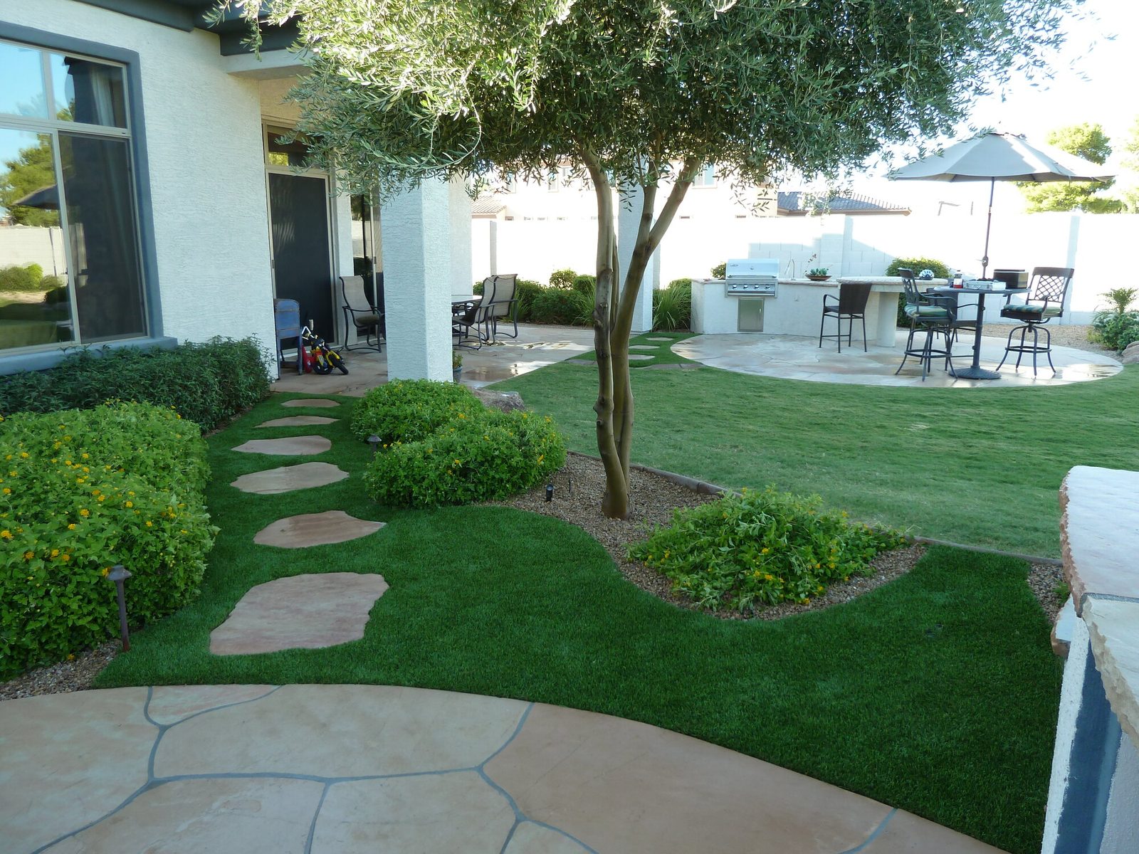 Turf yard with stepping stones to the patio, installed by Arizona Turf Masters