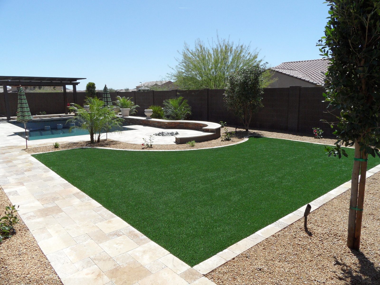 Backyard turf lawn with pool and fire pit, installed by Arizona Turf Masters