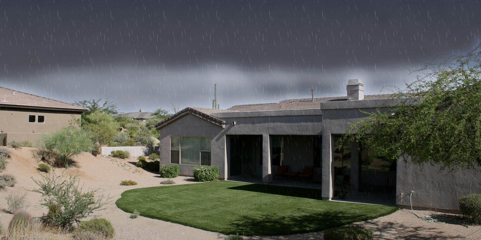 Monsoon storm clouds building over an Arizona Turf Masters artificial turf lawn in a Phoenix backyard