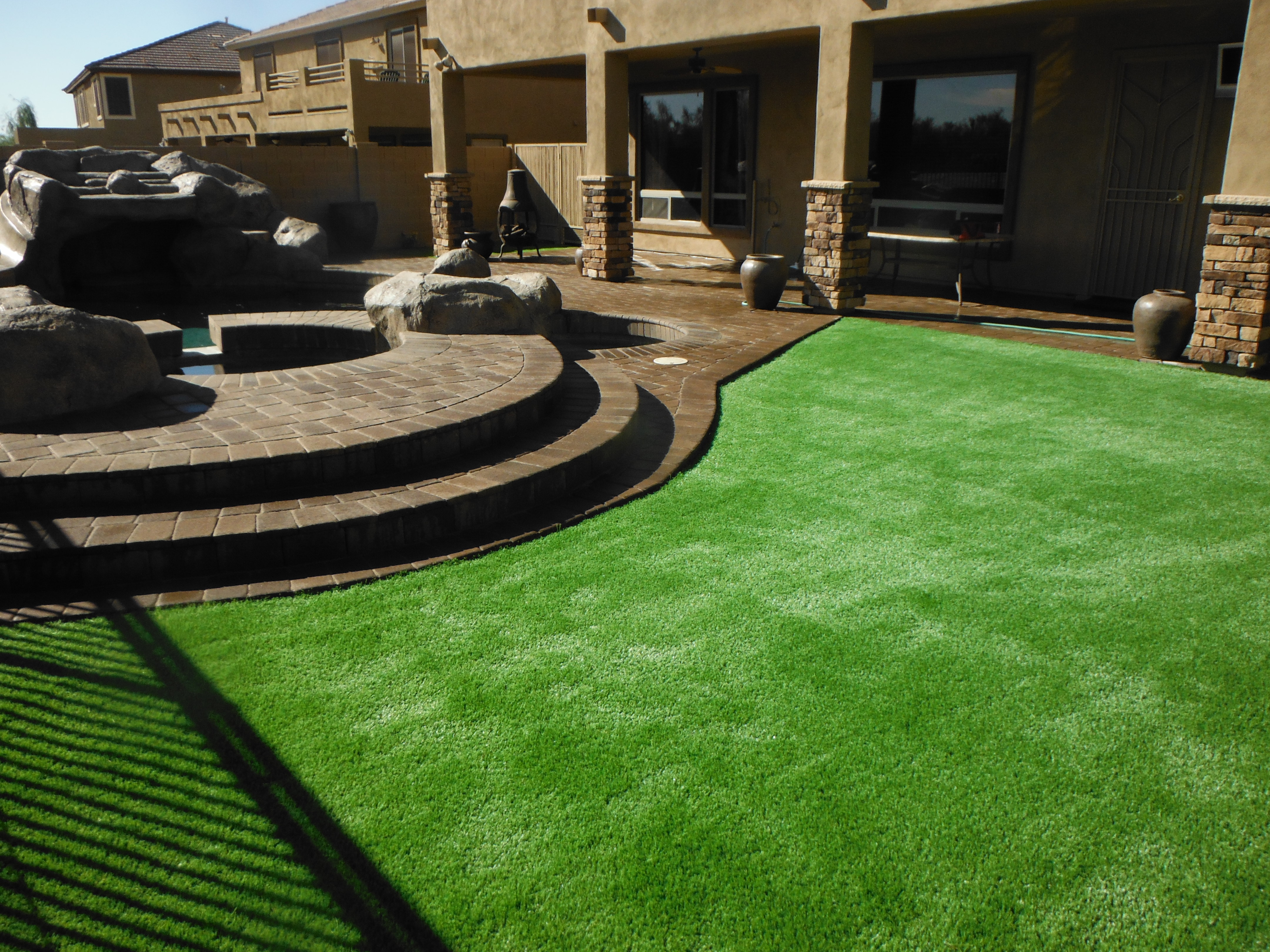 Backyard artificial turf lawn and paver patio installed by Arizona Turf Masters in Phoenix Arizona