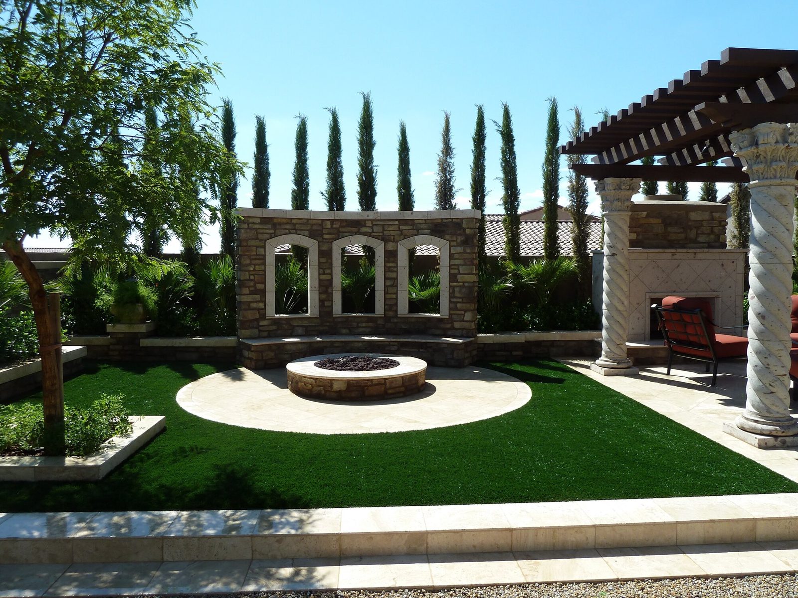 Turf lawn around a fire pit and pergola, installed by Arizona Turf Masters