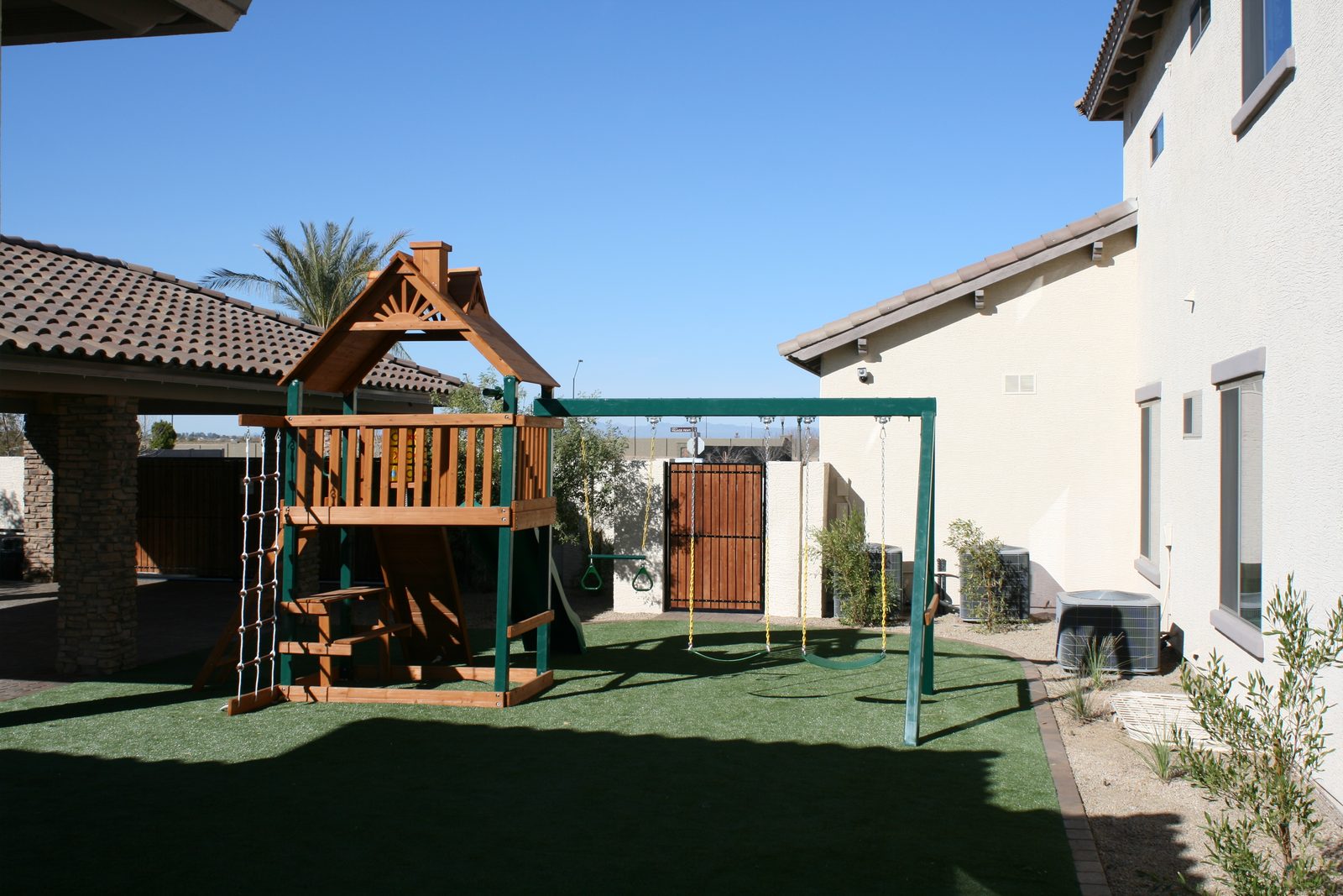 Playset on artificial turf in a backyard, installed by Arizona Turf Masters