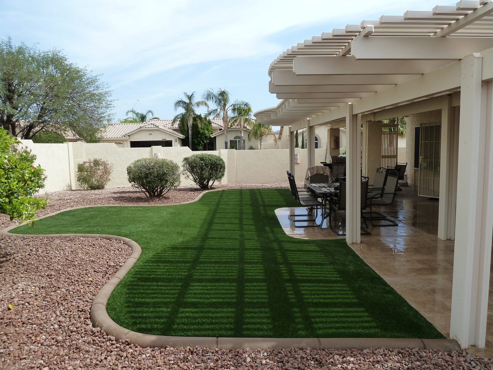 Pet friendly turf next to a covered patio, installed by Arizona Turf Masters